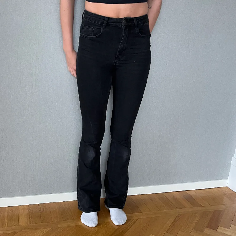 Svarta jeans från Pieces i lätt utsvängd modell. ”Peggy Flared Hw jeans” storlek S. Som man ser på bilden är de i använt skick och något slitna på knäna. Jeans & Byxor.