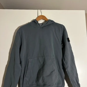 Stone island hoodie - Junior size,14 år, 170 cm. 9-10 i skick fint använt skick. Köpt ifrån NK från stockholm för 3 veckor sedan. Ny pris 1800kr. Passar även 152-170. Kommer med en extra knapp till stone island märket.