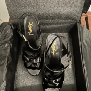 Klassiska YSL Tribute Sandaletter - Stl. 37, Dam Snygga klassiska Yves Saint Laurent sandaletter i nyskick, aldrig använda.  Kompletta med orginalkartong, reservklackar och dust bag.