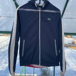 Lacoste jacka - Marinblå och röd Lacoste sport jacka i storlek small, Använd kondition.