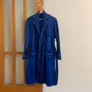 Jättecool klarblå jacka i badrock stil från Levi’s, inköpt i San Francisco. Fint glansigt tyg, men mjukt som fleece på insidan. Passar XS-M då den är lös i passformen. Matchande bälte finns med.