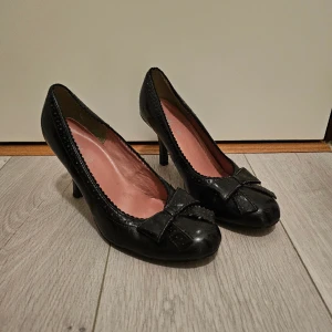 Rockabilly pumps - Beskrivning: Svarta lackpumps i rockabilly stil.  Märke: i.c.u Storlek: 38 Skick: Använda med en del märken, men i gott skick Material:  Nakenkatt finns i hemmet 