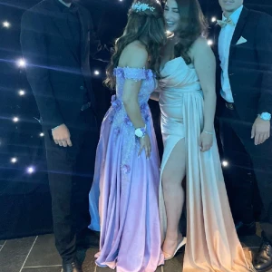 Balklänning💜 - Säljer min superfina balklänning från min bal 2023!💜Använd 1 gång, köpte den ny i butik, nypris 4000kr Klänningen är uppsidd (skräddarsytt) för att passa mig som är 162cm. Ljuslila med glitter, blommor och off shoulder💓storlek s/m sitter som en smäck