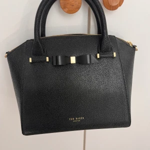 Ted Baker väska - Väskan är helt o använd och i gott skick. Den säljs heller inte längre i butik. Original bris var ungefär 3000, då den är gammal och kah vill bli av med den säljer jag den för 1000.