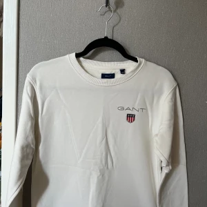  Vit bomull gant tröja  -  Vit Gant I ok skick fåtal defekter förekommer. Storlek 15 år vilket motsvarar 170 cm. Fråga privat om fler bilder.