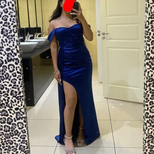 Klänning - Denna klänning funkar perfekt inför kommande event såsom bal och bröllop. Den är jätte fin med ett extra långt tyg i sidan men även en slits vid ena sidan av låret. 