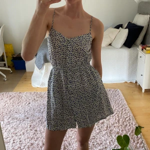 JC klänning - Blommig klänning från JC. Ena knappen (av två) längst upp har lossnat, annars fint skick!