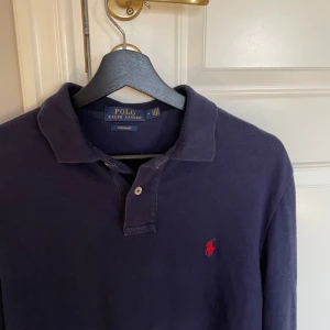 Ralph Lauren - blå Pikétröja - Mörkblå långärmad Ralph Lauren piké. Storlek: M, custom fit. Skick:9/10. Nypris:1700kr. Kontakta mig för fler bilder eller info!