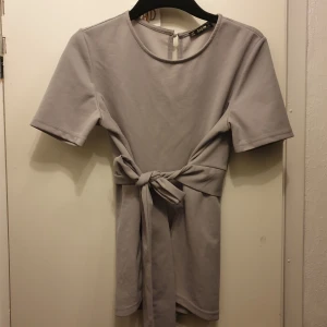 Fin grå/silvrig blus  - Passar m 🌸 aldrig använd, man kan välja om man knyter snöret fram eller bak.