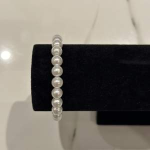 Detta 8 mm pärlarmband är perfekt för alla tillfällen, med sina glänsande pärlor som tillför en touch av klass och stil. Idealisk som present eller för att komplettera din egen smyckessamling.