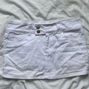 Minikjol - En vit minikjol med snygga detaljer vid knäppningen. Den är kort och lågmidjad. Köpt ny från H&M men säljer pga för liten storlek. Skriv för mått eller fler bilder💌