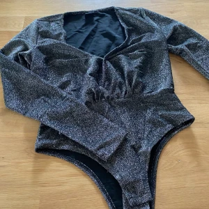 Body, glittrig - Glittrig body Bra kvalité  Frakten ingår i priset  Storlek M