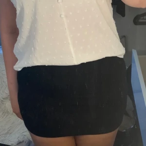 Svart kort kjol - Svart kort kjol med ett litet mönster 