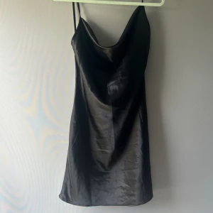 Satin klänning  - Jättefin klänning i satin material som inte kommer till användning. Öppen i ryggen och banden går i kors. Aldrig använd, inga deffekter🙌