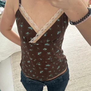 Brun topp med blåa blommor och spets - Köpt på vinted men passade inte riktigt:/ Annars fint skick