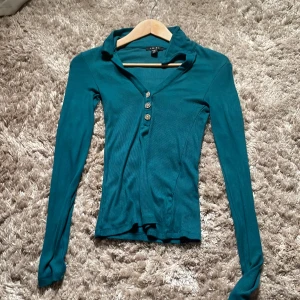En ish grön tröja - En långärmad tunn tröja Storlek xs  Har testat tröjan men inte använt  