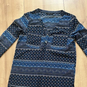Mönstrad topp - En mönstrad blå blus i storlek S/M 