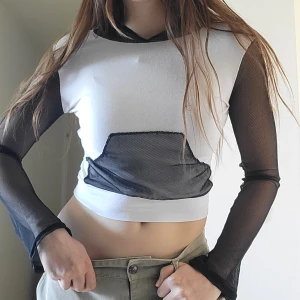 Y2K vit tröja med nätärmar - Inköpt mellan år 2000-2010. Typ världens häftigaste y2k tröja med svarta utsvängda nätärmar samt nätficka och luva!!😍 I jättefint skick. Passar XS-S, jag har själv S.