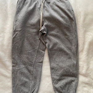 Gråa joggingbyxor i strl M från HM - Gråa joggingbyxor i strl M från HM.  Sparsamt använd och i fint begagnat skick.  Mått Midjan: ca 35 cm Längd från grenen och ner: ca 69 cm  Bomull, polyester och viskos  Kommer från ett djur och rökfritt hem.