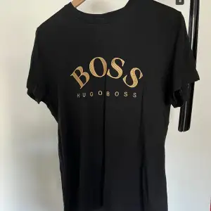 Äkta svart Hugo boss T-shirt i bra skick med sydd text , perfekt för sommaren.