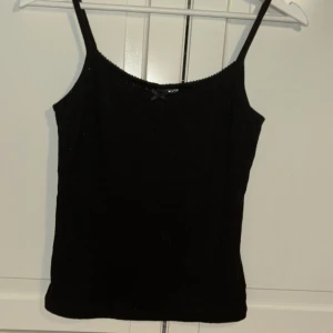 Gulligt svart linne  - Är använd få gånger och är i bra skick.  Ett svart fint linne går till nästan allting. En gullig liten rosett i mitten av uringningen. Går att diskutera priset❤️ Frakt från 15 kr🫶🏼 