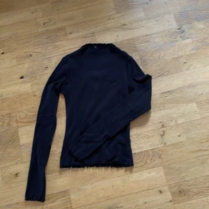 Fin långärmad t-shirt  - Fin svart ribbad långärmad t-shirt med frullig kant. Den går upp lite i halsen. Jättefin men jag har växt ur den. Bomull och elastane.