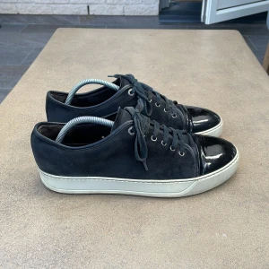 Lanvin black cap toe - Lanvin black cap toe - skick 7/10 då det finns skador på cap toe längst fram kolla bild 2 - bara skorna tillkommer - tvättade med lack polish ofta så fortfarande väldigt bra glans kan lacka dom mer innan frakt och köp - kom med bud och frågor i dm