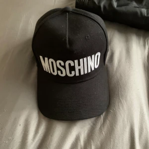 Moschino keps svart  - Fin keps helt ny och köpt på Johnells. Har ej kommit till användning då den inte är riktigt min stil. Nypris 1299