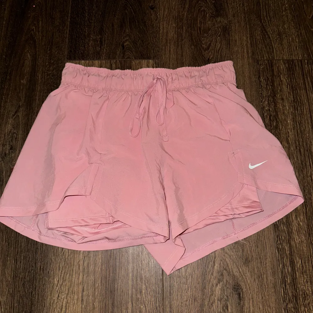 Ett par rosa Nike Tränings shorts! De är två shorts, underst ett par tighta sen överst ett par luftiga! Aldrig använda! Priset kan diskuteras!☺️💕. Shorts.