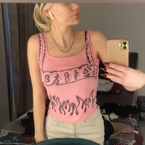 Retro linne - Rosa linne med texten "tattoo" och flammor  Ingen lapp på men skulle säga storlek s Skriv om frågor😊 Kolla bio