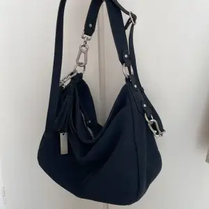  Mörkblå väska med många bra fack och två axelremmar så man kan använda den som både handväska och axelväska. Endast använd ett fåtal gånger.