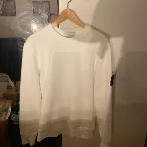 Helt oanvänd vit stone island sweatshirt. Skick 10/10. Ny pris 3000kr. Det står att den är storlek M, dock är den stor som en S.