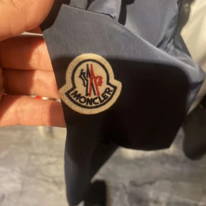 MONCLER VINDJACKA - Fin, skön MONCLER vindjacka. Äkta jacka som är i nyskick väldigt bekväm och pussar för sommaren, vintern, höst och våren. Matchar med många andra kläder.