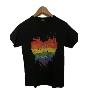 Svart t-shirt med regnbågsmotiv från Gildan. Nästan aldrig använd så det är i mycket bra skick.