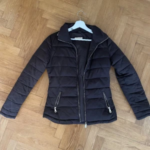 Brun vinterjacka - Fin Vinterjacka från Massimo dutti i brun med guld ditaljer.   Stilren med justerbart band i ryggen för att justera midjan.   Storlek XS/S.  Utan anmärkningar.  Hämtas i Stockholm