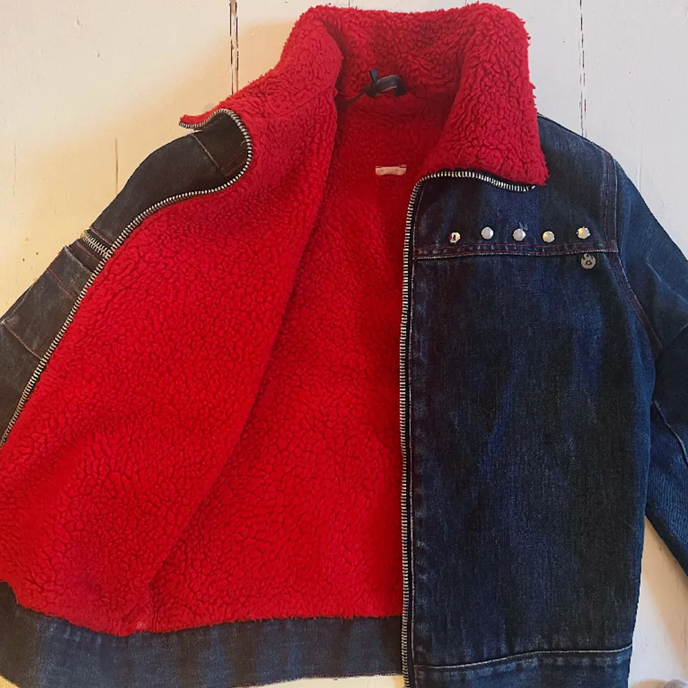 Acne jeansjacka med rött teddyfoder och nitar fram och bak. I jättefint skick och passar S-M. OBS, den är vintage och därav en Acne Action jacka . Jackor.
