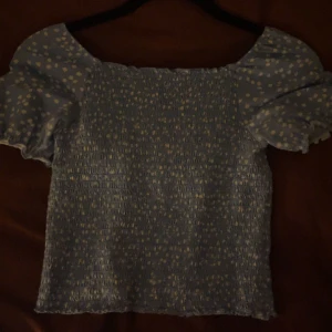 Blommig sommartopp - En jättefin vit-blå blommig topp från Kappahl som inte säljs längre. Tyvärr inte kommit till användning pga storlek. Jättebra skick!💞