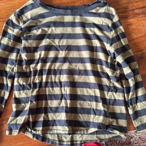 Randig olivgrön/svart tröja - Väldigt fin tröja, säljes då den är för liten.   Priset är inklusive frakt!