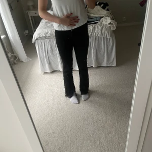 Jeans - Svarta jeans med en slits längst ner vid benen. Högmidjade. Jag är 170 cm