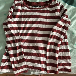 Randig vit/vinröd tröja - Bra skick! Endast använd någon enstaka gång. Säljes då den är för liten.
