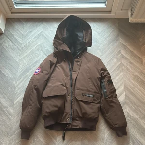 Canada Goose liknande jacka  - Fin jacka som liknas canada goose, kan inte garantera äktheten. Varm och go jacka, med äkta dunfjädrar. Använt skick. Säljes för en billig peng eftersom jag inte vet om den är äkta eller inte.  Storlek motsvarar XS herr och M dam. Skickas.