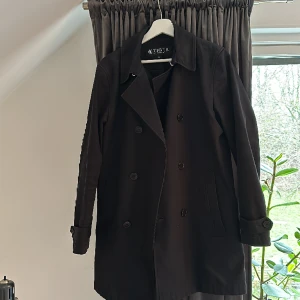 Svart trenchcoat Tiger of Sweden stl. 46 - Svart trenchcoat från Tiger. Använd men i fint skick.