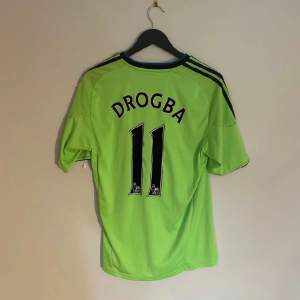 Chelseas officiella tredjetröja från 2010 med Chelsea legenden Drogba #11 på ryggen. Tröjan är i grymt skick utöver en missfärgning strax under Samsung sponsorn.   Produktkod P00189