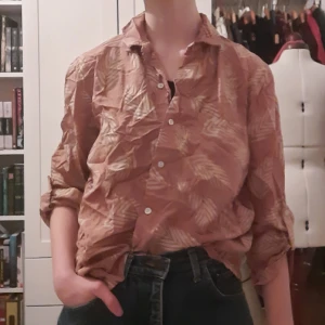 Rosa skjorta med glittriga löv - Superhärlig skjorta i gammelrosa med guld/glittrigt löv tryck! Sorry för rynkorna, har legat undanstuvad länge... sorlek M men funkar prima för S också!