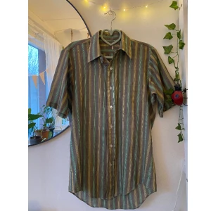 Retro randig skjorta  - Säljer denna superfina randiga retro-skjortan i färgerna grön, gul och brun✨den är kortärmad och av tunt material. Märke: okänt, men köpt på second hand. Oerhört fint skick! Skriv om du har frågor :)