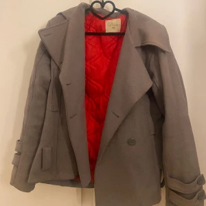 Kort kappa - Säljer denna så fina kappa då jag inte använder den längre, påminner om de populära kapporna från design by si💕den har tappat två knappar som syns på bilderna men det är inget man tänker på💕den är i storlek 40 men skulle även passa 38