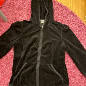 Svart juicy couture  - Så snygg svart juicy couture med ttekvartsärmar! Lite dammig på bilderna men inte alls sliten. Köpt second hand i new york och använd några gånger av mig men som sagt inte alls några slitage💓storlek xl men passar mig med s och även m superbra 