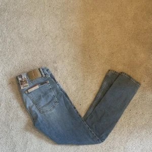 Helt oanvända Nudie Jeans 31/30 - Säljer ett par Nudie Jeans som är helt oanvända, se lappen på tredje bilden! ||Modell: Skinny Lin || Skick: 10/10 || Sorlek: W31/L30 || Passform: vanliga/ tighta || Nypris: 1600    Frågor och funderingar? Hör gärna av dig!