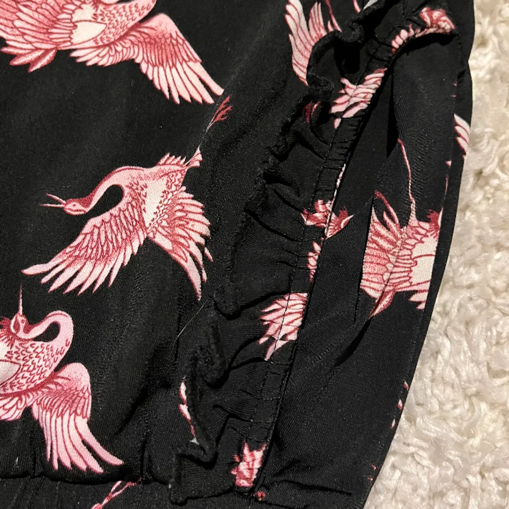 Ett par svarta mjukisbyxor med flamingo motiv på! Använt fåtal gånger. Har fickor på sidorna där fram! . Jeans & Byxor.