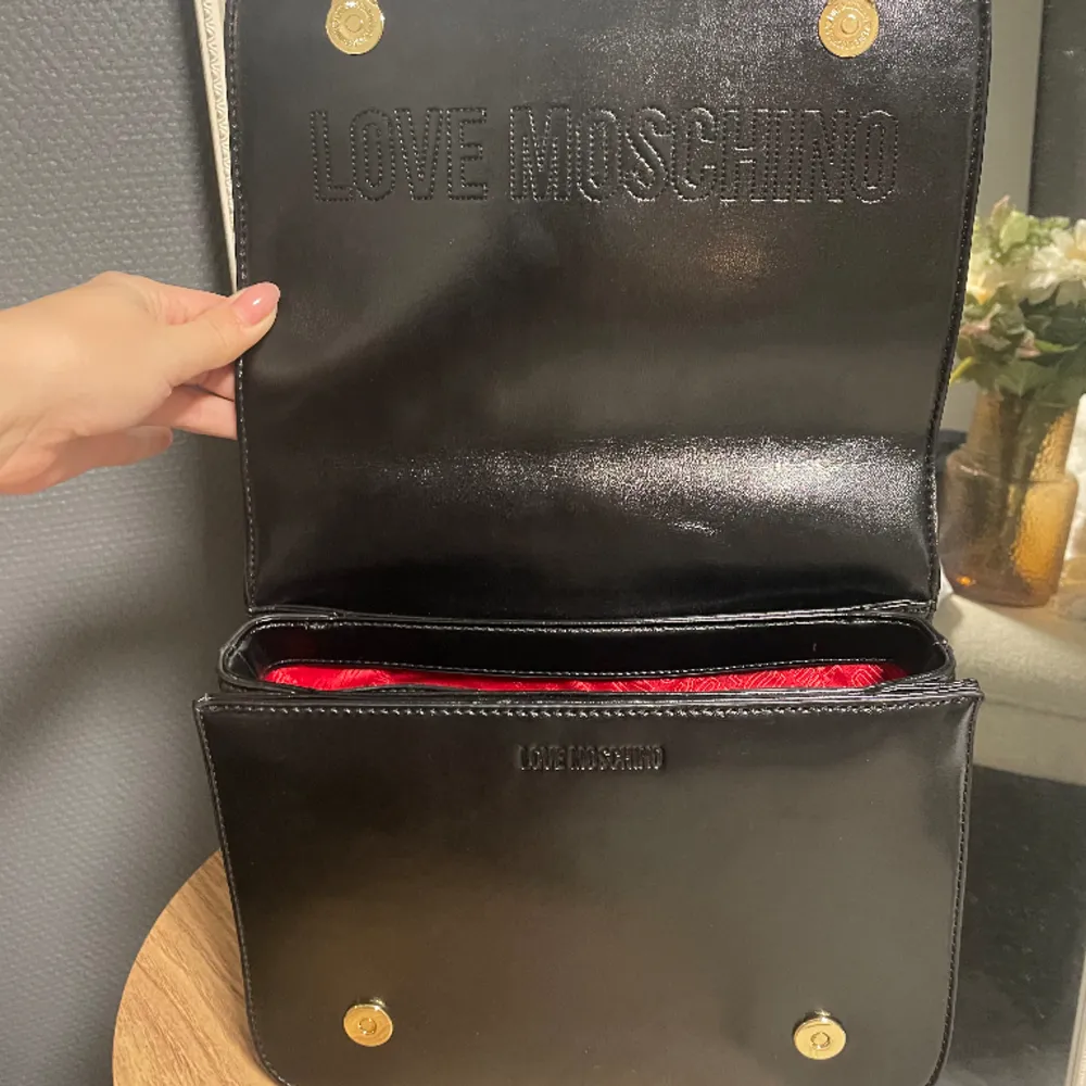Helt oanvänd Moschino väska! Längd: 33 cm Höjd: 23,5  Djup: 12, 5 cm . Det finns tre fack och en med dragkedja. Väskan stängs med magnet knapp 🥰🥰 Köpt för ca 3000kr . Väskor.